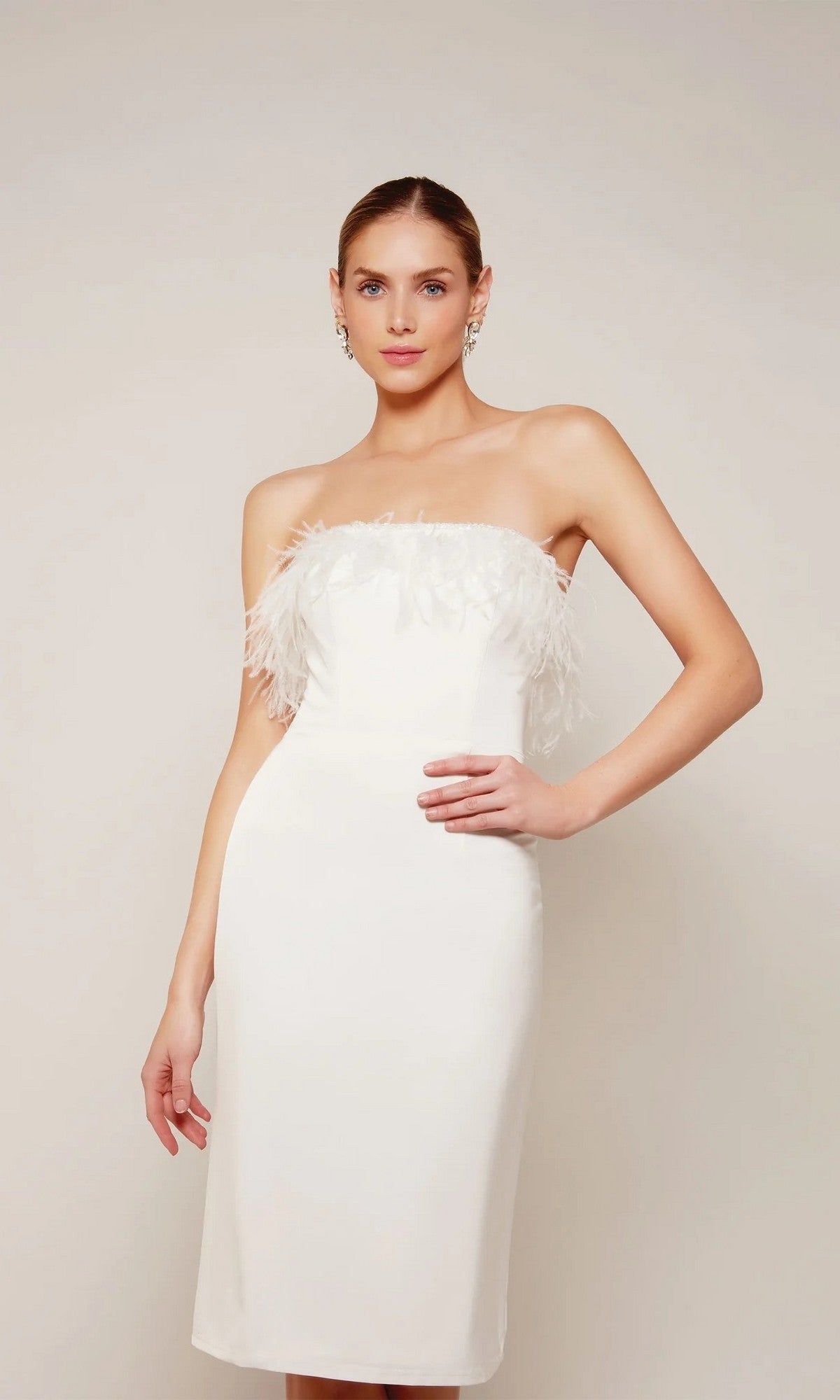 Woman in the Alyce 70028 Knee Length Semi-Formal Dress in ivory, featuring a strapless design with feather detailing—an elegant choice for cocktail parties and special occasions.